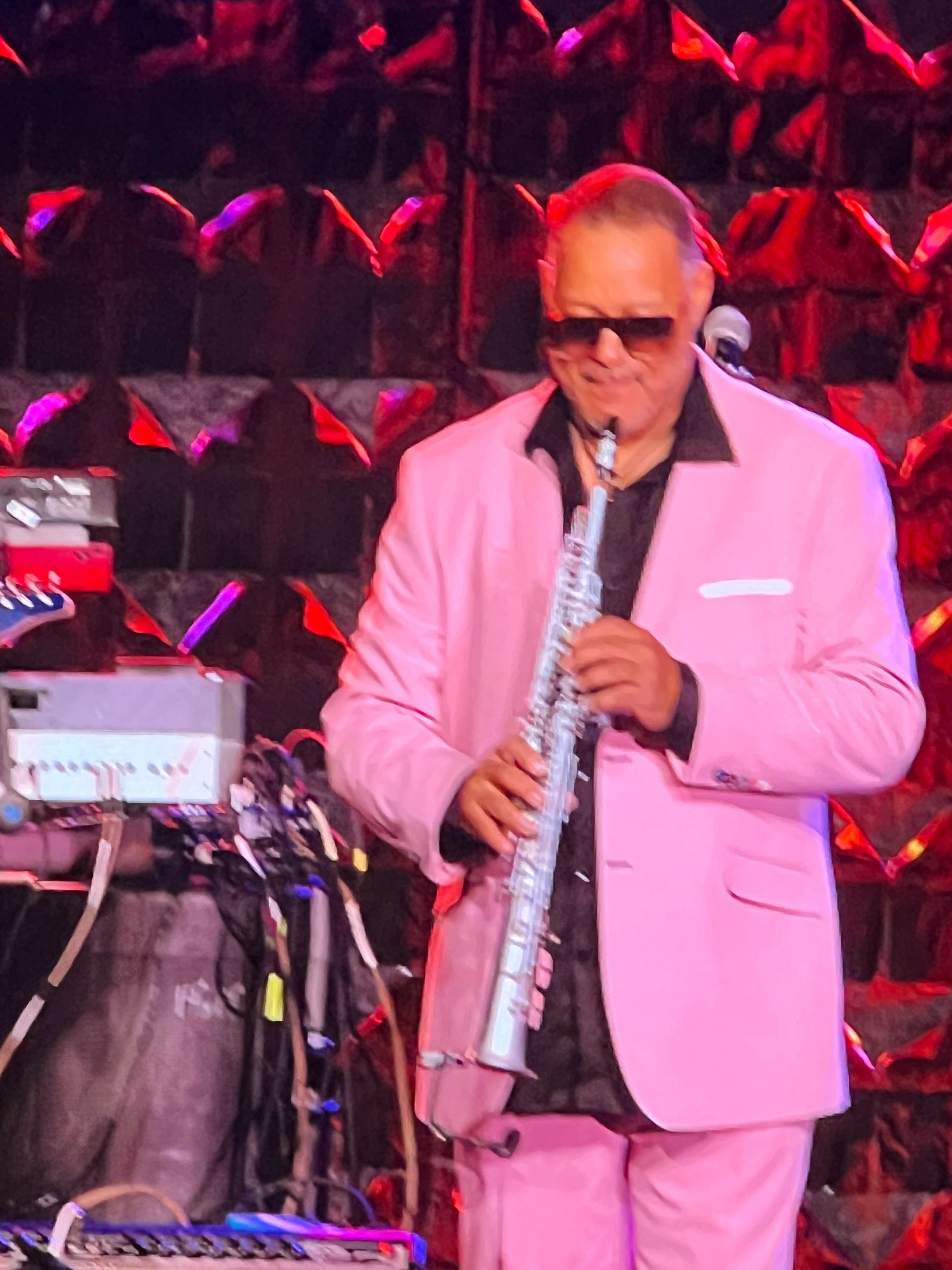 Guitarist pink suit concert stage red lighting